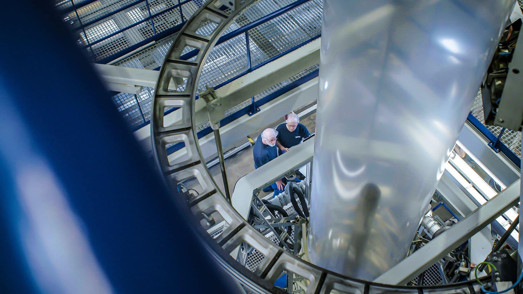 Ein Foto aus der Produktion der Firma Wentus GmbH. Man kann eine große Maschine und einige Mitarbeiter von Wentus GmbH erkennen.